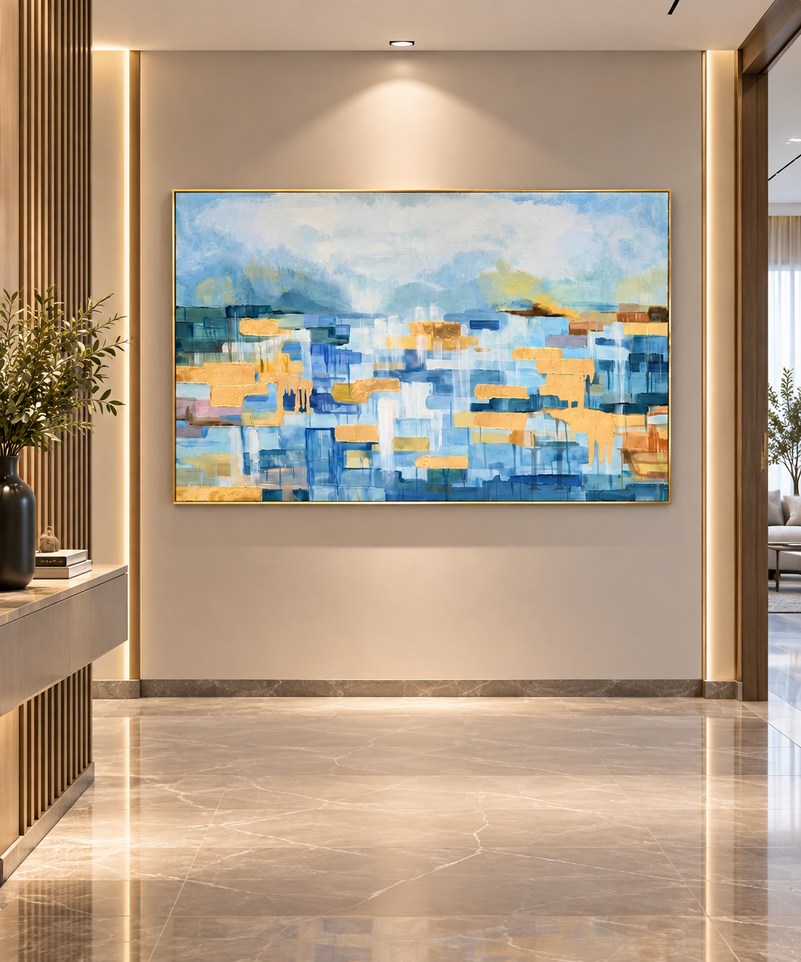 An abstract painting with blue, yellow, and white brushstrokes, framed in gold and hung on a beige wall in a modern, well-lit hallway with marble floors.