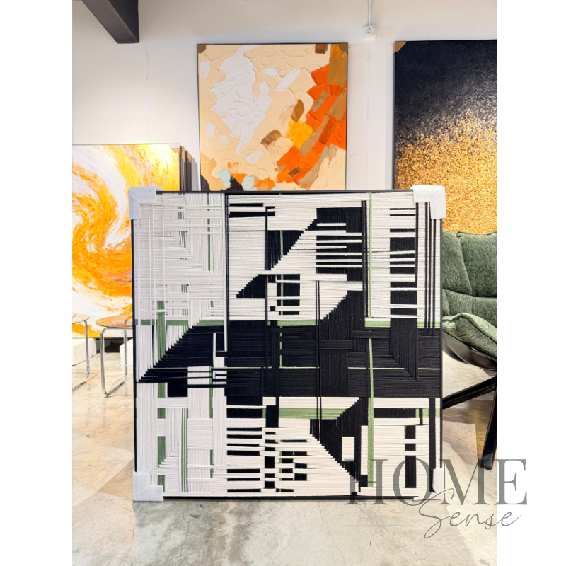Handcrafted modern geometric thread wall art with black, white and sage green woven design in a black aluminium frame.